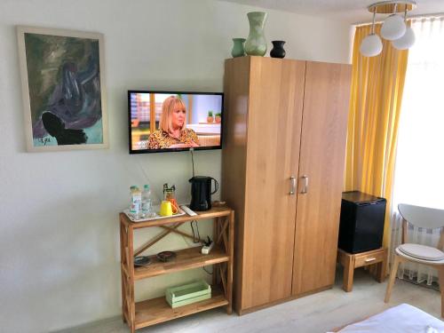 a living room with a tv on a wall at Haus am Kurpark in Schömberg