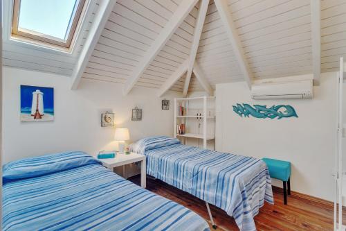 two beds in a room with white walls and a window at Waterfront apartment Palma in Kralendijk