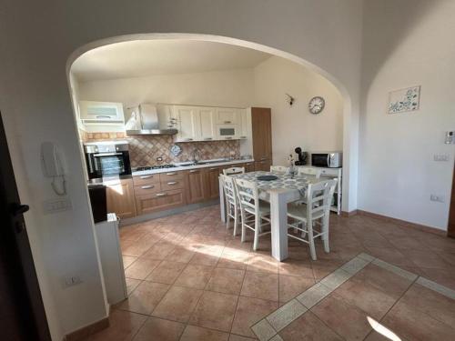 Una cocina con una mesa y sillas en una habitación. en Casa Boi Dessena 1, en Orosei