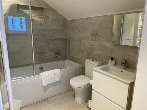 uma casa de banho com uma banheira, um WC e um lavatório. em Strother's Townhouse em Berwick-Upon-Tweed
