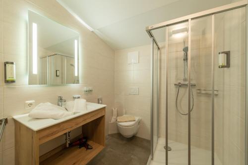 a bathroom with a shower and a sink and a toilet at Pension Haus in der Sonne in Fieberbrunn