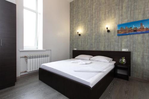 ein Schlafzimmer mit einem großen Bett mit weißer Bettwäsche in der Unterkunft Апартаменты на Гиршмана 4 in Kharkov