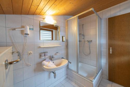 uma casa de banho com um lavatório e um chuveiro em Pension Haus in der Sonne em Fieberbrunn