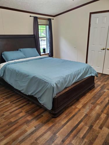 um quarto com uma cama grande e piso em madeira em Forest Hills ATV Resort 