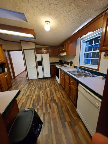a small kitchen with wooden floors and white appliances at Forest Hills ATV Resort in Forest Hills