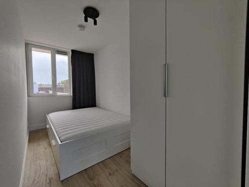 a small bedroom with a bed and a window at K50169 Modern apartment near the center and free parking in Eindhoven