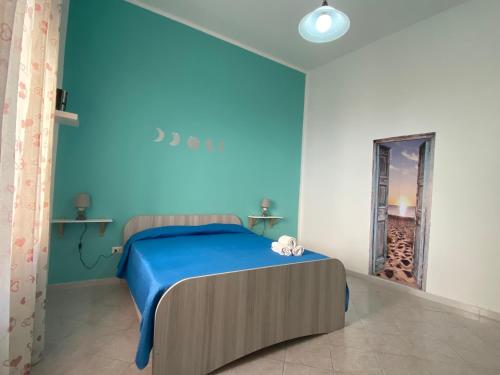 una camera blu con letto e specchio di La Casetta di Azzurra a Canneto