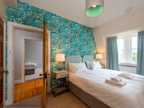 um quarto com uma cama grande e um espelho em Rosebery Place em Gullane