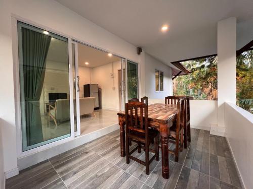 een eetkamer met een tafel en stoelen bij Naisang Hostel in Chumphon