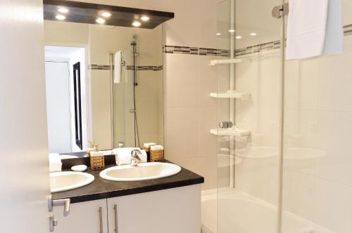 a bathroom with two sinks and a shower at Belfort - Appartement 2 chambres avec ascenseur et Parking in Bordeaux