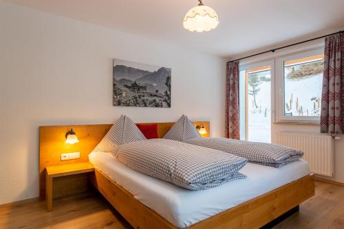 a bedroom with a bed and a large window at Pension Haus in der Sonne in Fieberbrunn