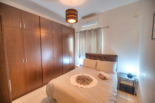 1 dormitorio con 1 cama grande y armarios de madera en Large and modern 2bedroom with balcony GLUB1-1, en Il-Gżira