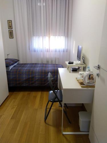 a bedroom with a bed and a desk with a computer at Affittacamere da Alina in Argelato