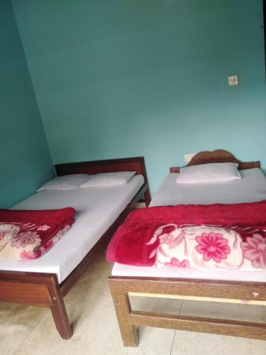 two beds sitting next to each other in a room at Access Villa in Nuwara Eliya