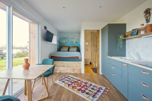 Il comprend une cuisine avec une table et une chambre avec un lit. dans l'établissement Le Panoramik - Pont-Réan, à Guichen
