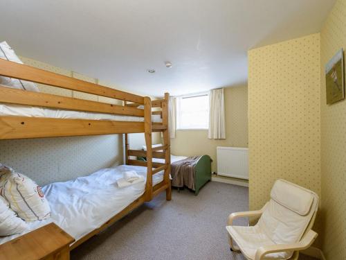 a bedroom with two bunk beds and a chair at Southcot in North Berwick