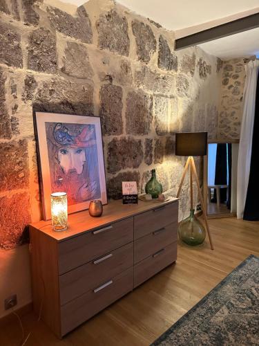 a dresser in a room with a stone wall at Appartement Lavande et Jasmin in Anduze