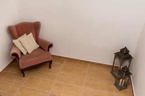 a brown chair with a pillow on a tiled floor at Krab in Rewal