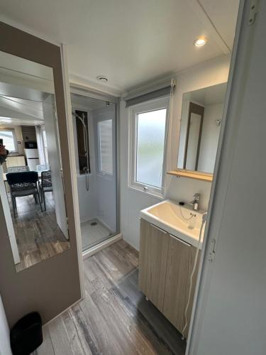 a bathroom with a sink and a mirror at La côte sauvage - MH climatisé 2018 - P30 - Le Portel in Le Portel