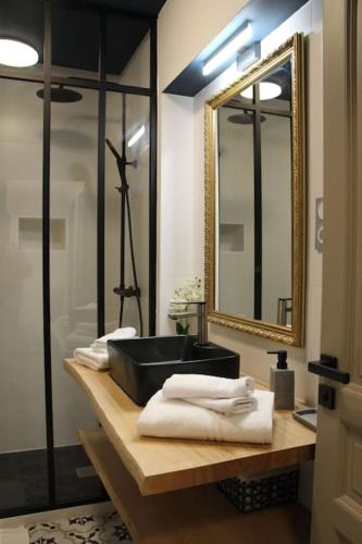 une salle de bain avec un lavabo noir et un miroir dans l'établissement Chez Franck et Gisele, à LʼIsle-sur-la-Sorgue