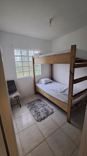 sypialnia z 2 łóżkami piętrowymi i oknem w obiekcie A-List Villas w mieście Rodney Bay