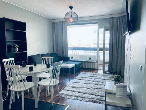 a living room with a table and chairs and a couch at Tapiola Center Apartment in Espoo