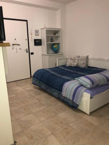 Schlafzimmer mit einem Bett mit blauer Decke in der Unterkunft Virgy’s House in Sestu
