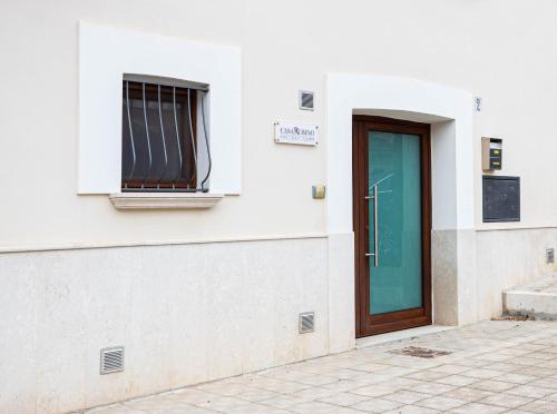 a white building with a door and a window at Casa Rubino Holiday Home - 50mt dal centro in Troia