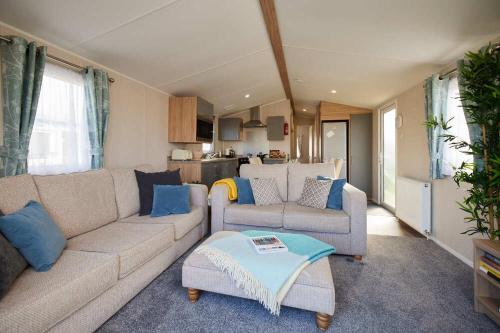 a living room with a couch and a table at Nirvana Coastal Retreat Holiday Home in Cayton