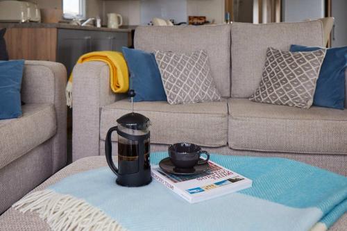 a coffee table with a tea kettle on top of a couch at Nirvana Coastal Retreat Holiday Home in Cayton