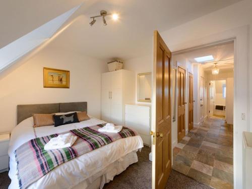 a bedroom with a bed and a staircase with an attic at Goose Green View in Gullane