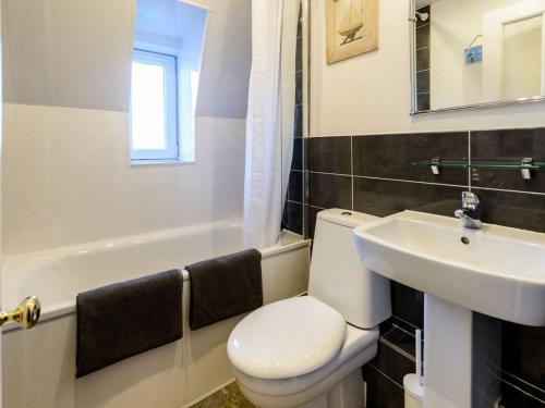 a bathroom with a white toilet and a sink at Goose Green View in Gullane