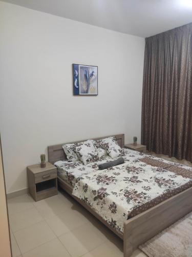 um quarto com uma cama e duas mesas de cabeceira em Tiamooz Room in shared Apartment em Ajman