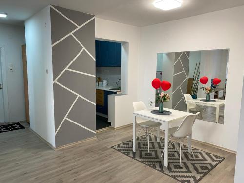 Un comedor con una mesa y sillas blancas. en Regina's Modern Apartment2, en Skopje