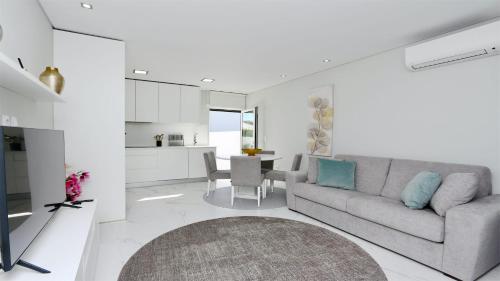 a living room with a couch and a table at Marina Retreat - CleverDetails, for 2 adults and 2 children, Jacuzzi, near the Marina and the beach in Vilamoura