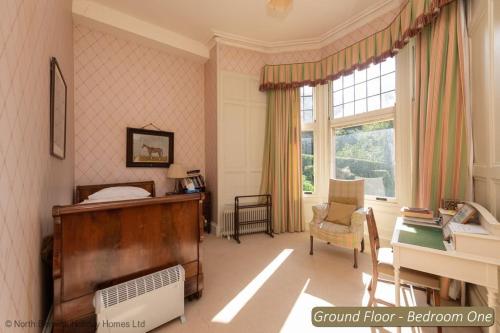 a bedroom with a bed and a desk and a window at St Colms Main House in North Berwick