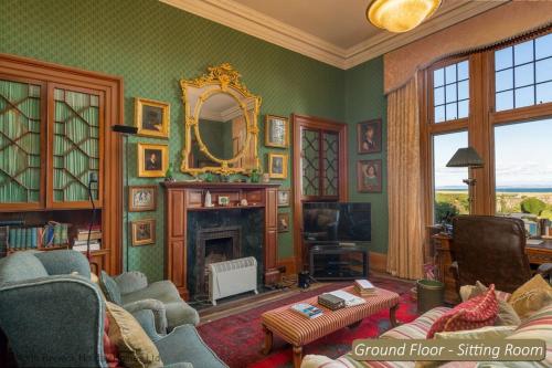 a living room with a fireplace and a mirror at St Colms Main House in North Berwick