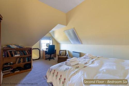 a bedroom with a bed and a chair and a book shelf at St Colms Main House in North Berwick