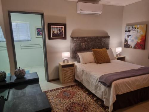 1 dormitorio con 1 cama y 2 mesitas de noche en Alimandi Nursery Cottage, en Ciudad del Cabo