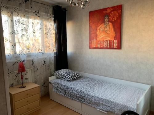 1 dormitorio con 1 cama y una pintura en la pared en Jolie chambre Nenuphar dans belle maison, en Vaulx-en-Velin