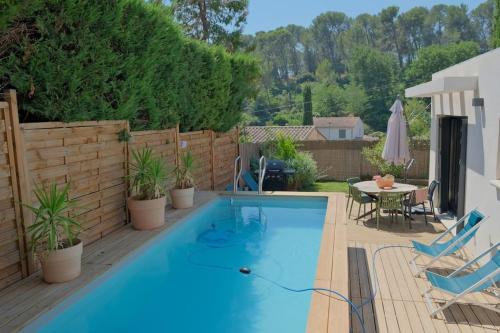- une piscine sur une terrasse avec une table et des chaises dans l'établissement Villa Ethan, à Aix-en-Provence