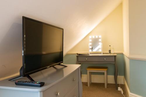 a flat screen tv sitting on a dresser in a room at Woodlands Lodge Hotel in Bartley