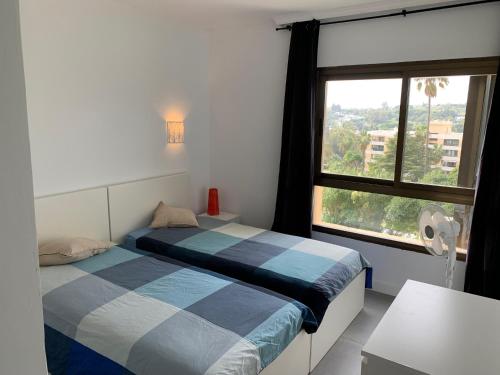 マルベーリャにあるNice Flat close to Puerto Banusのベッドルーム1室(ベッド2台、大きな窓付)