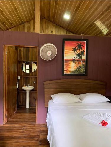 a bedroom with a bed and a bathroom with a sink at Hidden Paradise Lodge in Drake