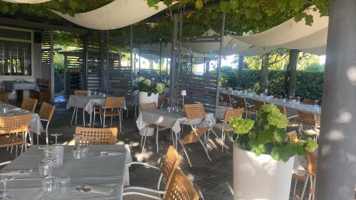 a restaurant with white tables and chairs and plants at Casa vacanze Girardi in Gorizia