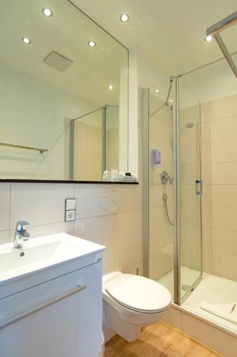 a bathroom with a toilet sink and a shower at Hotel am Fischerstrand in Bansin