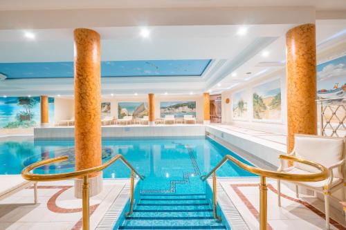 a swimming pool with two columns and two chairs in a hotel at Arkona Strandresidenzen in Binz