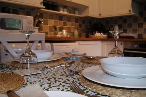 a kitchen counter with plates and bowls on a table at Top Floor at Cantref House in Brecon