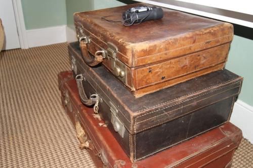 três malas empilhadas uma em cima da outra com uma câmara em cima em Top Floor at Cantref House em Brecon