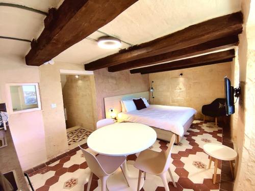 - une chambre avec un lit, une table et des chaises dans l'établissement Coast 52 Savynomad Harbour Residences wow Views, à La Valette